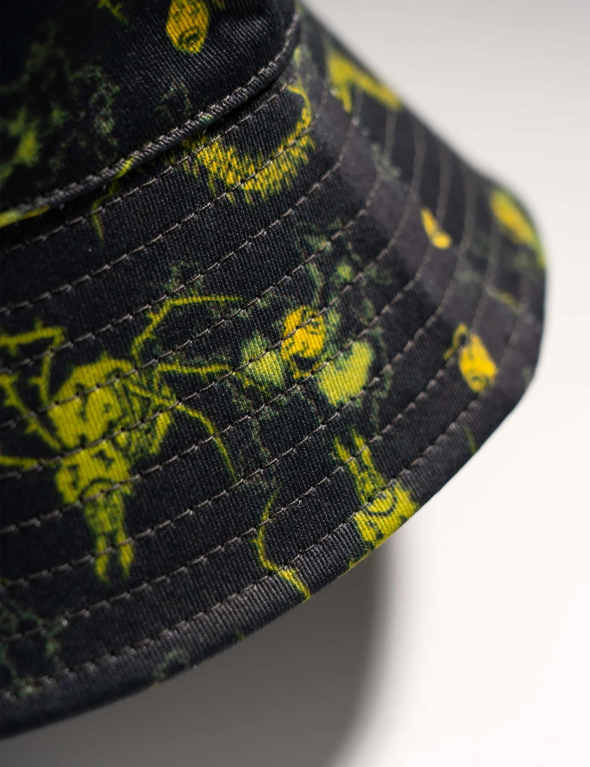 High-definition detail of the screen printed graphic on the Creepy Crawlies Green Bucket Hat - Creep Cast Merch